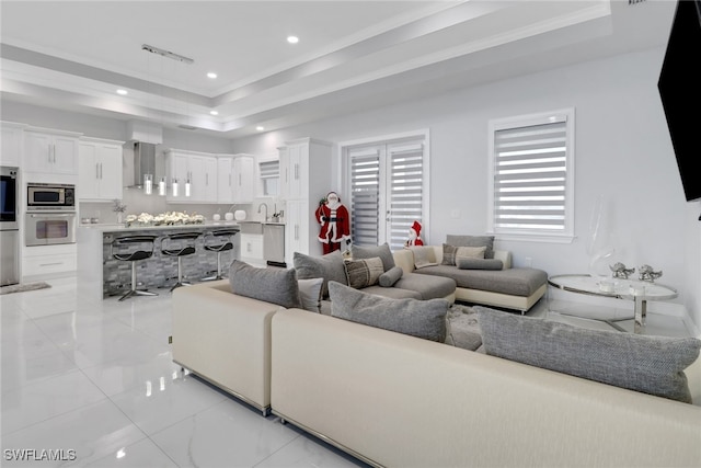 living area featuring ornamental molding, recessed lighting, a raised ceiling, and marble finish floor