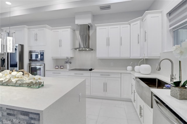kitchen with stainless steel appliances, white cabinets, visible vents, and wall chimney range hood