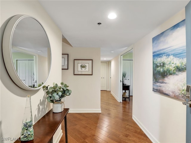 hallway featuring recessed lighting, wood finished floors, and baseboards