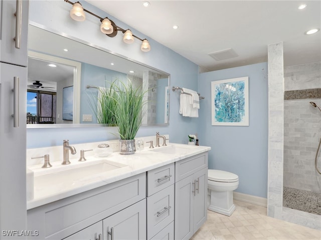 bathroom featuring double vanity, a sink, toilet, and a walk in shower