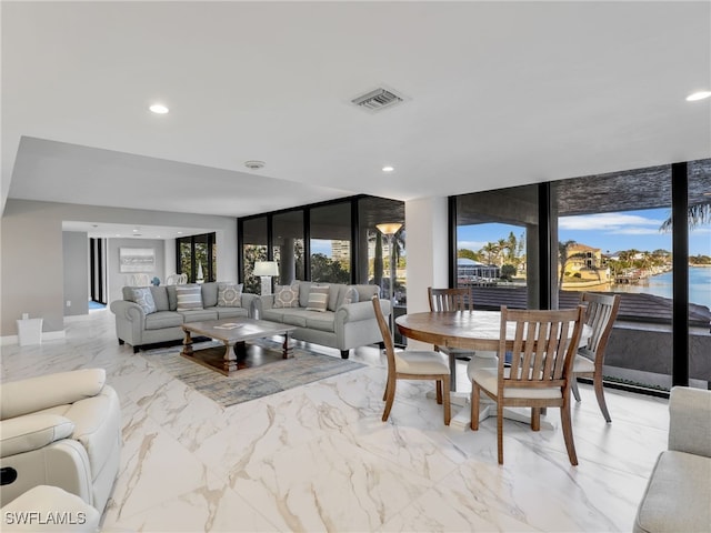 dining area with plenty of natural light, a water view, visible vents, and recessed lighting