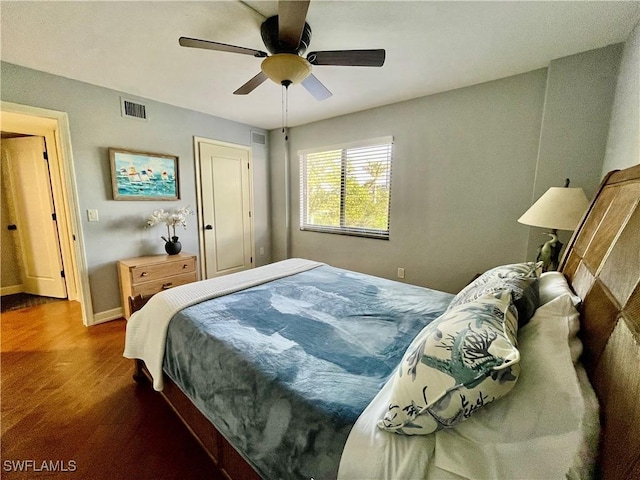 bedroom featuring baseboards, a ceiling fan, wood finished floors, and visible vents