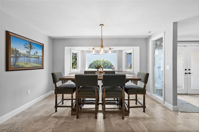 dining room with a notable chandelier and french doors