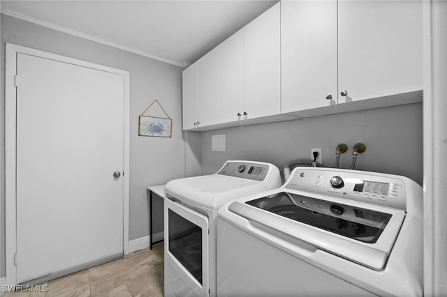 clothes washing area with cabinets and washing machine and clothes dryer