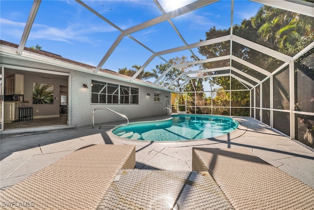 view of swimming pool with a lanai and a patio