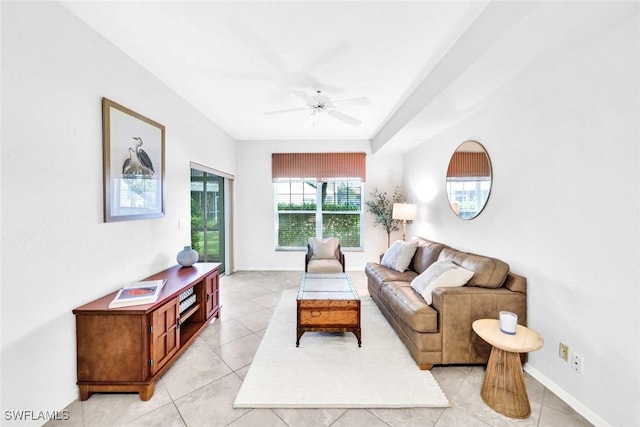 living room featuring a ceiling fan, baseboards, and light tile patterned floors