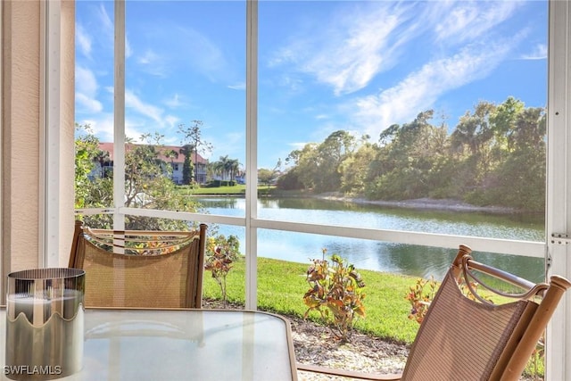 sunroom / solarium featuring a water view