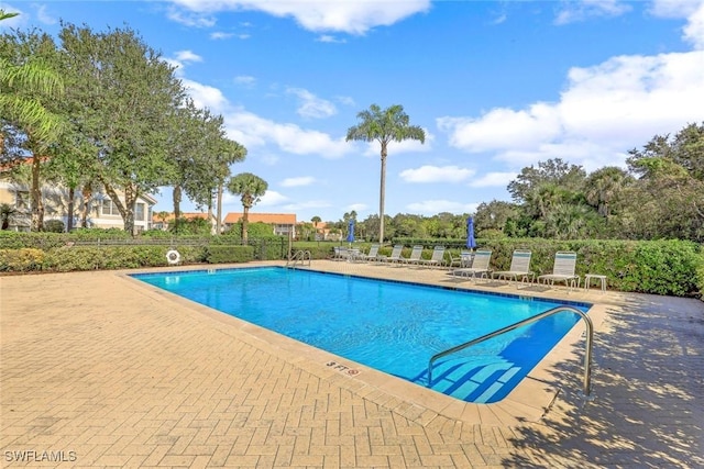 pool with a patio and fence