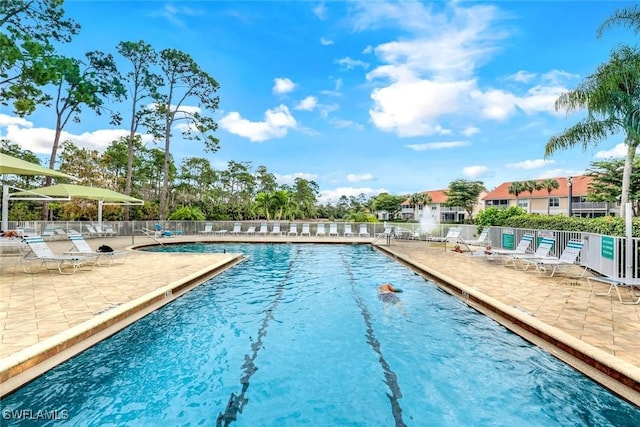 pool with a patio area and fence