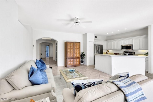 living room featuring light tile patterned floors, arched walkways, a ceiling fan, and recessed lighting