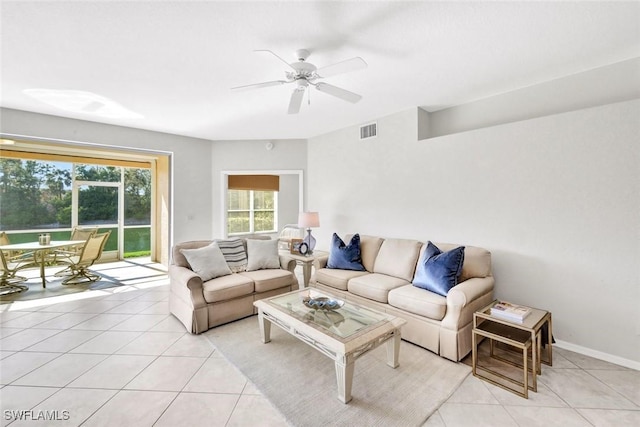 living area with visible vents, ceiling fan, baseboards, and light tile patterned flooring