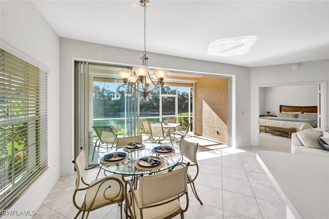 dining space with light tile patterned floors and an inviting chandelier