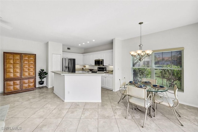 kitchen with a notable chandelier, baseboards, white cabinets, hanging light fixtures, and appliances with stainless steel finishes