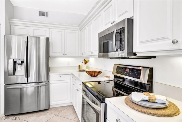 kitchen with light tile patterned flooring, stainless steel appliances, visible vents, white cabinetry, and light countertops