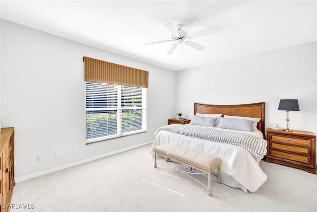 carpeted bedroom with ceiling fan and baseboards