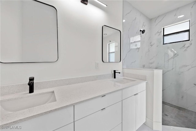 bathroom with vanity and a tile shower