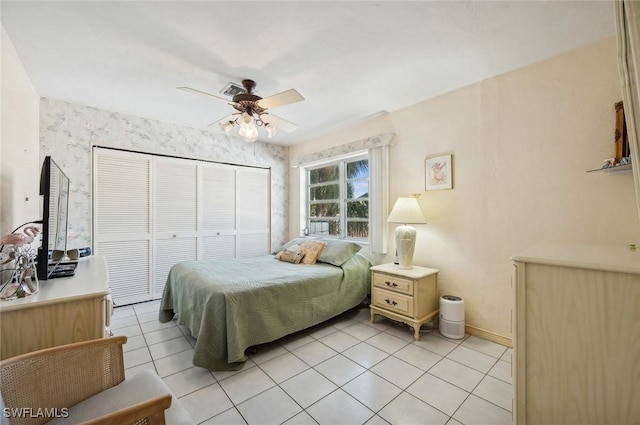 tiled bedroom with ceiling fan and a closet