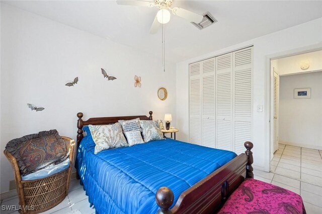 bedroom with light tile patterned flooring, ceiling fan, and a closet