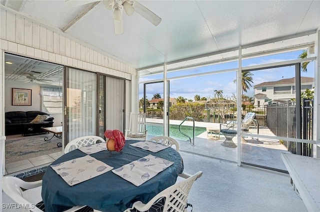 sunroom / solarium featuring a water view and ceiling fan