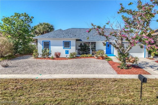 ranch-style house with a garage and a front lawn