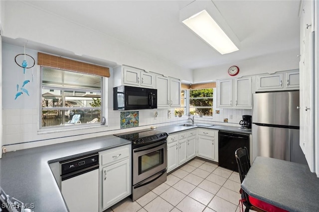 kitchen featuring tasteful backsplash, sink, white cabinets, light tile patterned floors, and black appliances