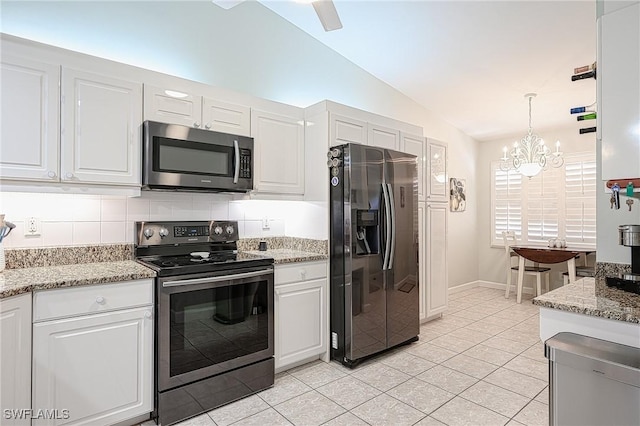 kitchen featuring pendant lighting, vaulted ceiling, white cabinets, and appliances with stainless steel finishes