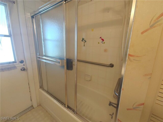 bathroom with bath / shower combo with glass door