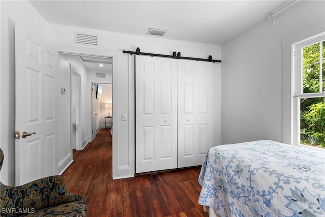 3475 Edgewood Ave, Fort Myers, FL 33916 - bedroom featuring dark wood-type flooring, a barn door, and a closet