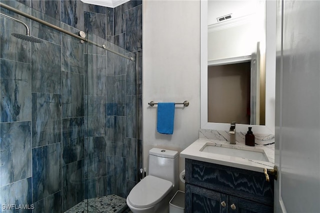 bathroom with vanity, a tile shower, crown molding, and toilet