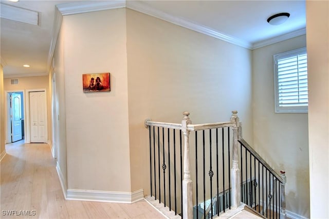 hallway with light hardwood / wood-style flooring and ornamental molding