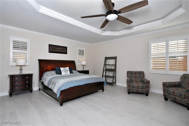 bedroom featuring ornamental molding, a tray ceiling, and light hardwood / wood-style floors