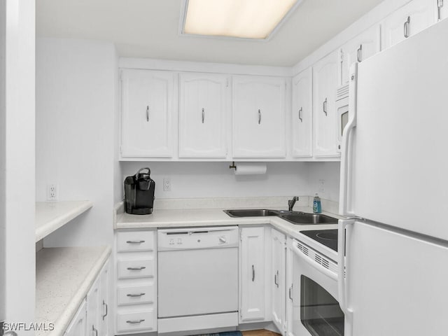 kitchen with white appliances, sink, and white cabinets