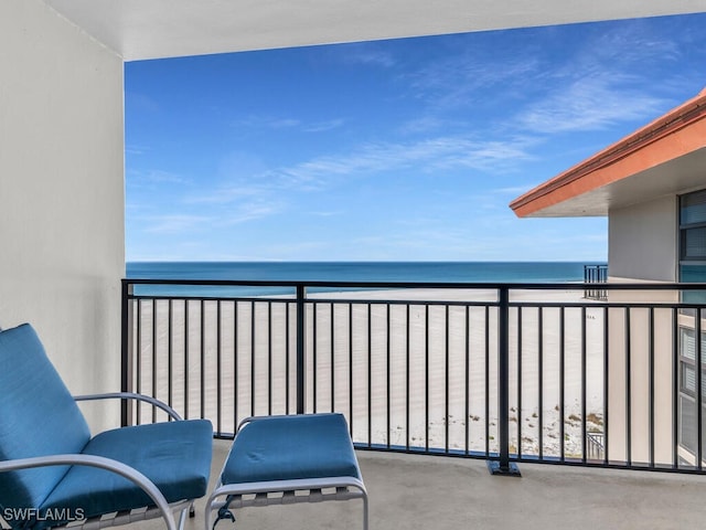 balcony featuring a water view and a beach view