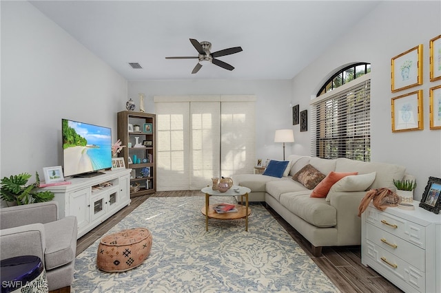 living room with dark hardwood / wood-style floors and ceiling fan