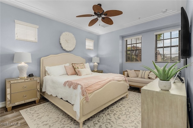 bedroom with crown molding, light hardwood / wood-style floors, and ceiling fan