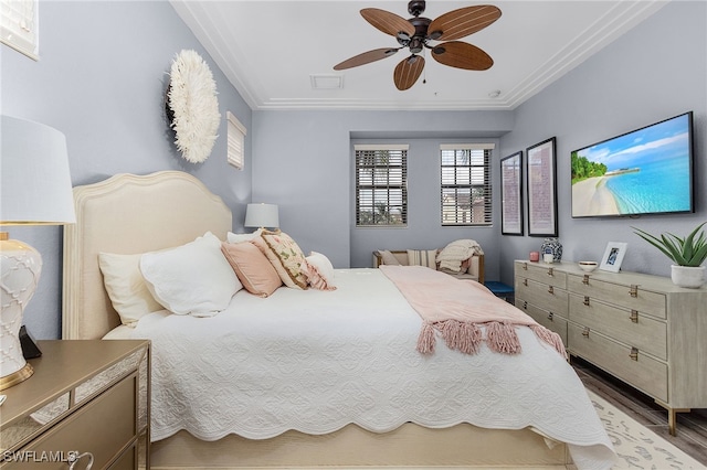 bedroom featuring hardwood / wood-style floors, ornamental molding, and ceiling fan