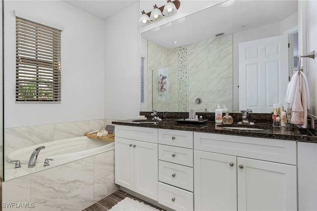 bathroom featuring vanity and independent shower and bath