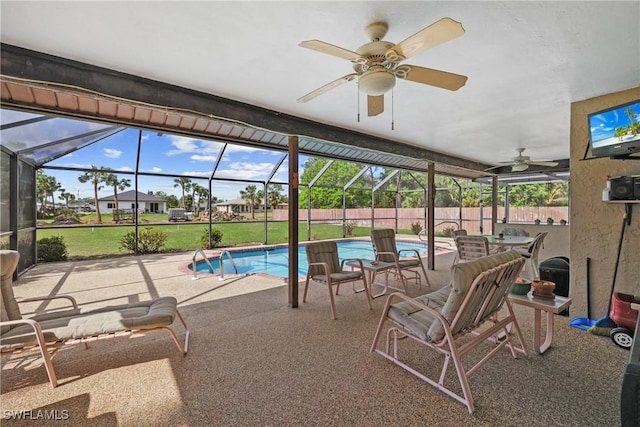 view of swimming pool featuring ceiling fan, a yard, a lanai, and a patio