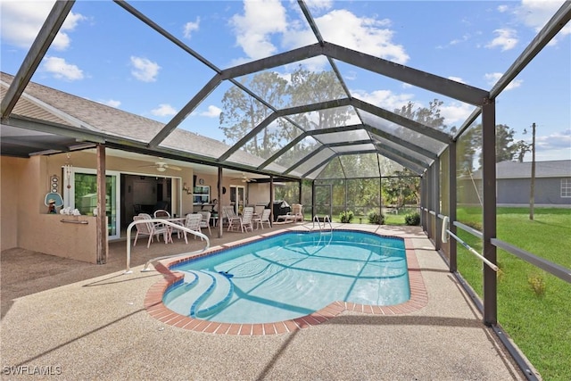 view of pool featuring a patio, ceiling fan, and glass enclosure