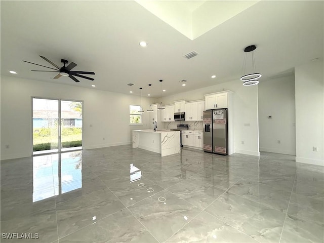 unfurnished living room featuring sink and ceiling fan