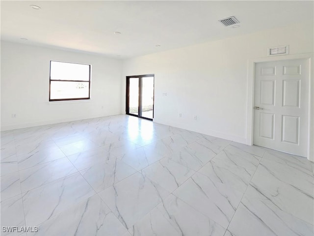 unfurnished room with marble finish floor, french doors, visible vents, and baseboards