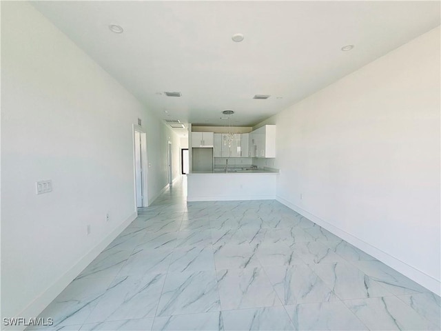 unfurnished living room featuring marble finish floor, visible vents, and baseboards