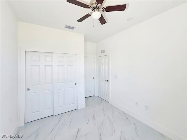 unfurnished bedroom featuring marble finish floor, baseboards, visible vents, and a closet