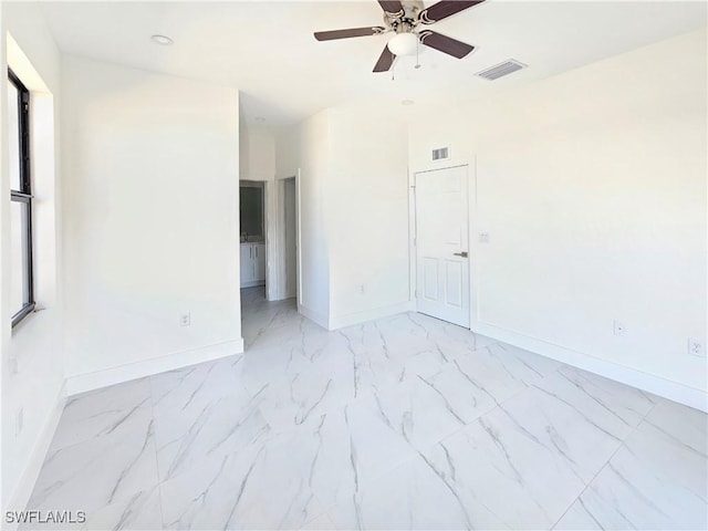 unfurnished room with marble finish floor, visible vents, and baseboards