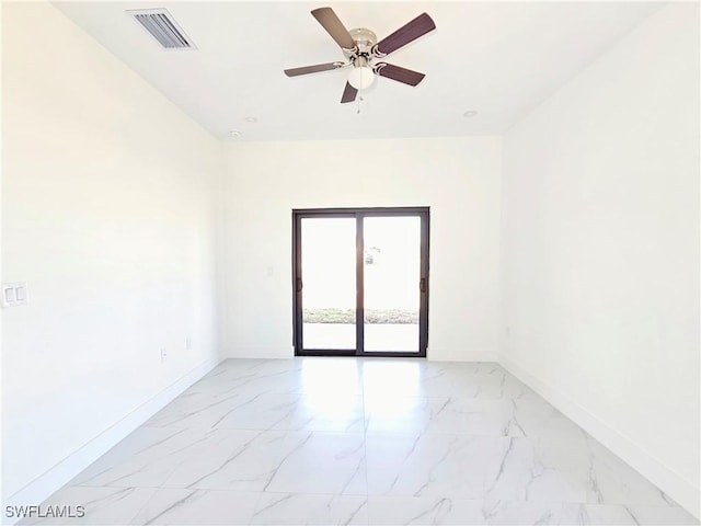 spare room featuring a ceiling fan, marble finish floor, visible vents, and baseboards