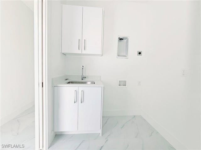 washroom featuring marble finish floor, cabinet space, a sink, and hookup for an electric dryer