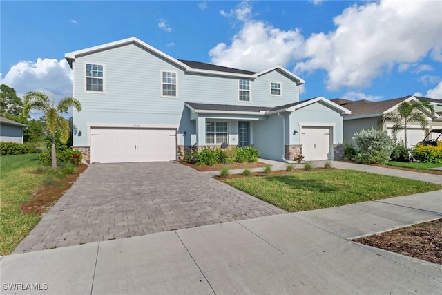 view of property featuring a front lawn and a garage