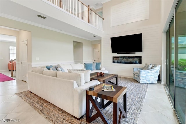 tiled living room featuring ornamental molding and a high ceiling