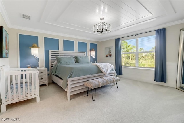 carpeted bedroom with a tray ceiling, ornamental molding, and an inviting chandelier