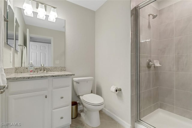 bathroom with toilet, a shower with shower door, vanity, and tile patterned flooring